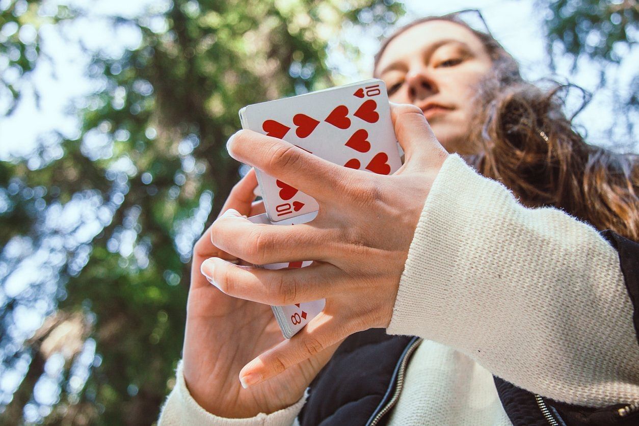 girl uses a deck of bicycle playing cards to do a card magic trick