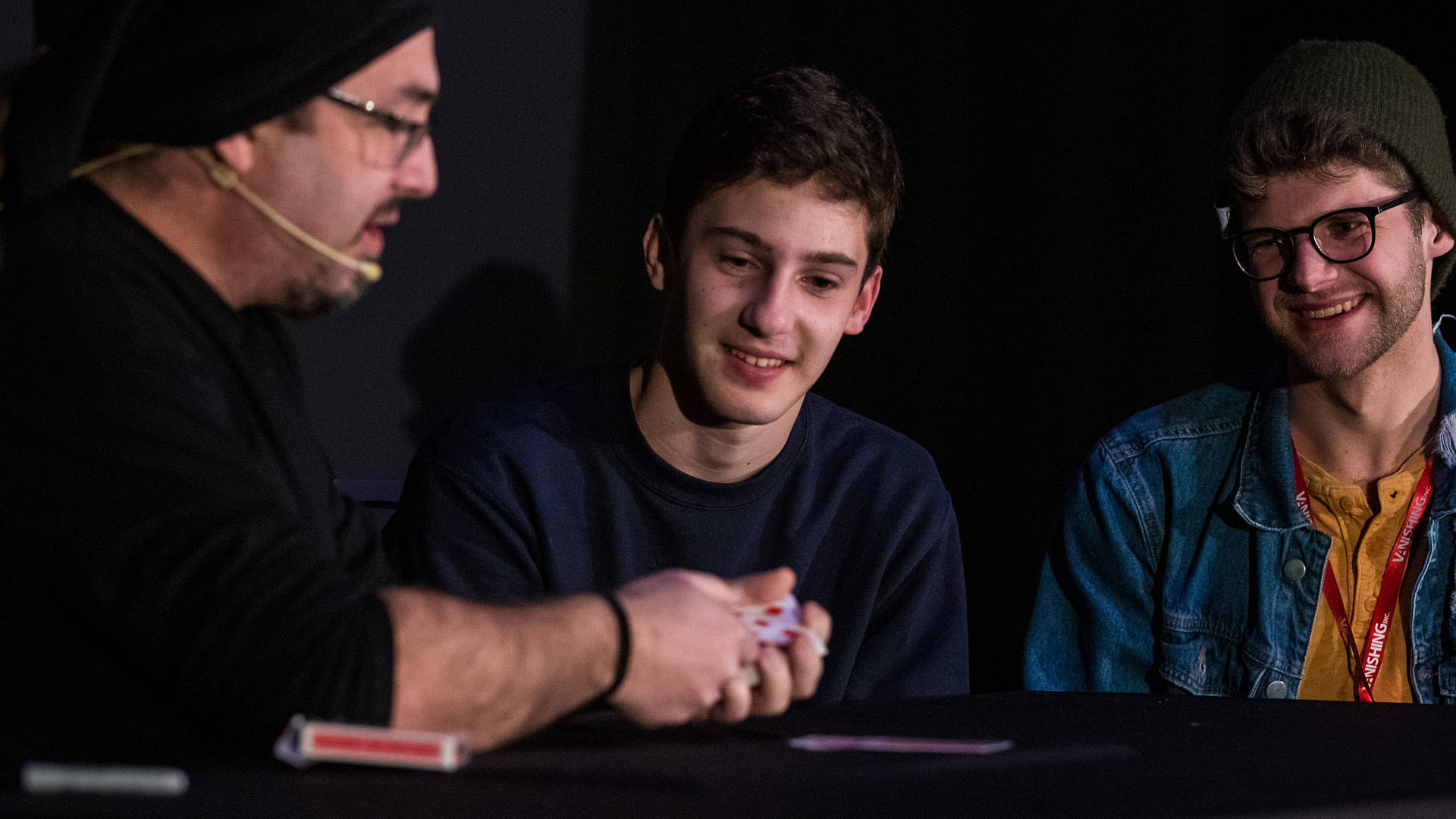 dani daortiz magician performs a card magic tricks for men on stage