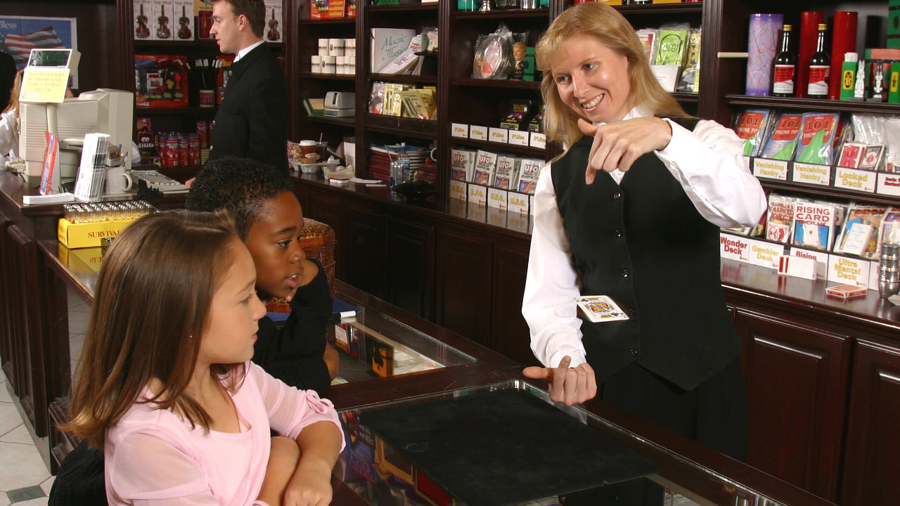 female magician performs amazing card tricks at disneyland magic shop main street magic
